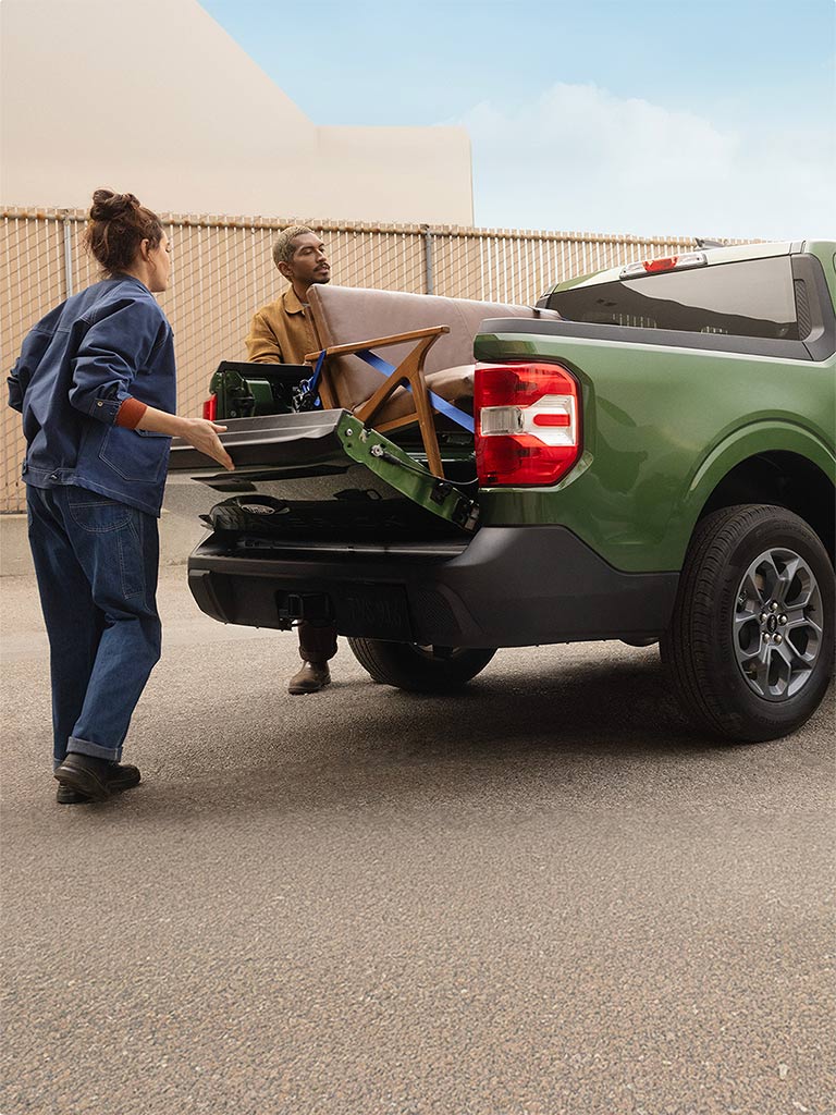 Dos personas cargando la amplia caja del Ford Maverick