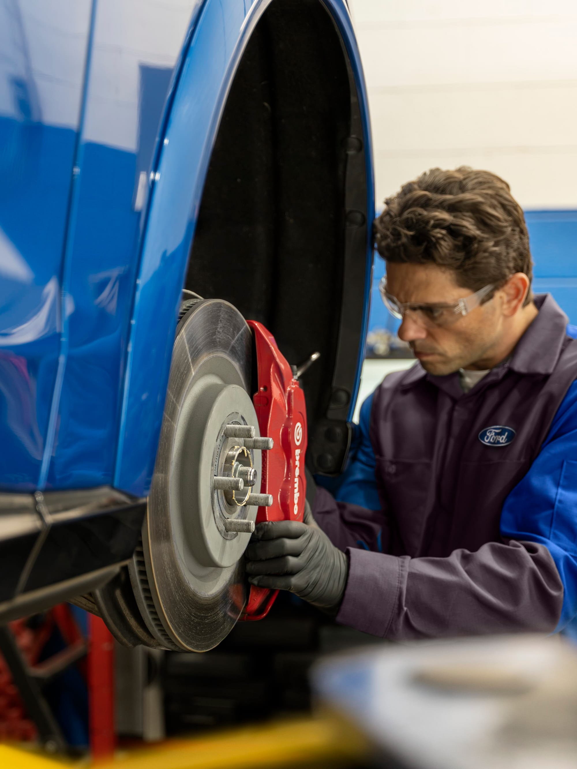 Mecánico Ford haciendo mantenimiento de frenos