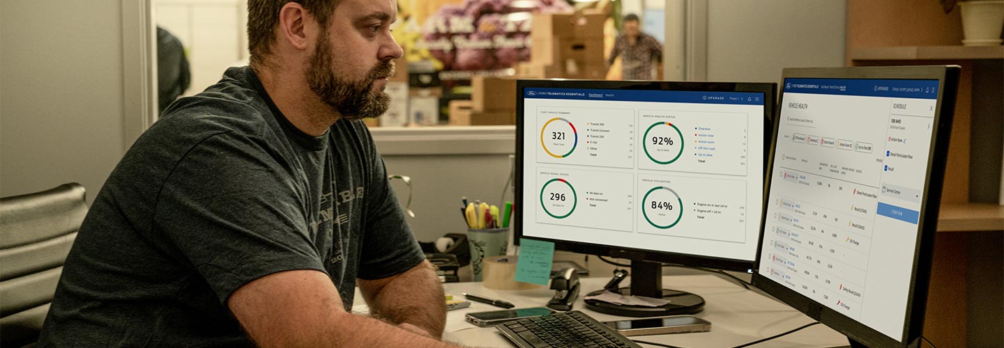 Hombre observando dos monitores monitoreando la actividad de la flota